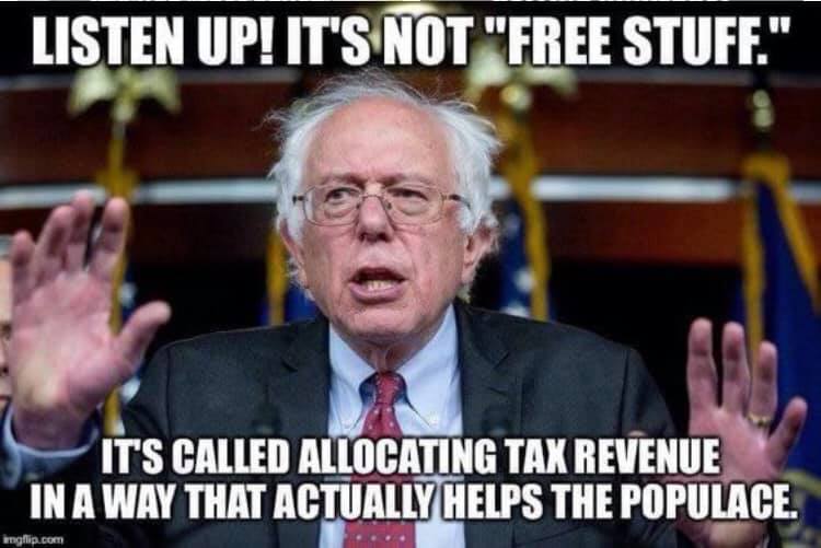 This meme is an image of Bernie Sanders with his mouth open and a shocked expression. The text above him reads, "LISTEN UP! IT'S NOT 'FREE STUFF.' IT'S CALLED ALLOCATING TAX REVENUE IN A WAY THAT ACTUALLY HELPS THE MIDDLE CLASS." The image is meant to be humorous and satirical, implying that Sanders is reacting to a misunderstanding about his policies.